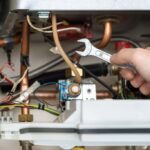 Technician is holding wrench in front of combi gas boiler