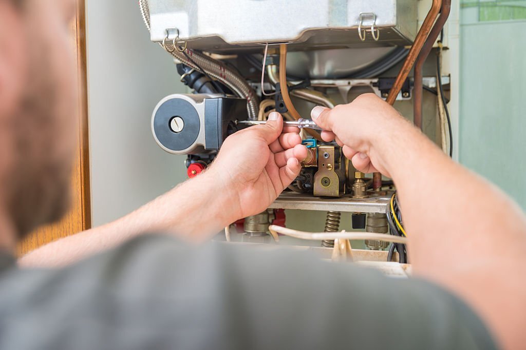 Technician repairing Gas Furnace.